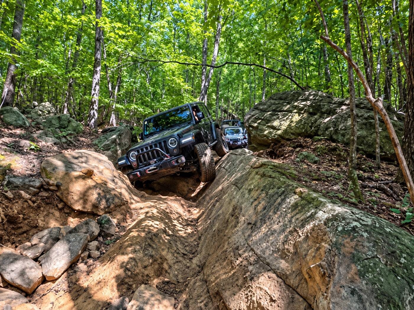 Jeeps climbing a rock channel between boulders on Uphill Both Ways